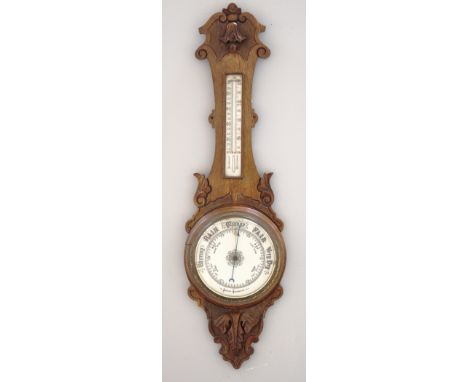 Oak aneroid banjo shaped barometer, ceramic dials, carved decoration, 90cms.