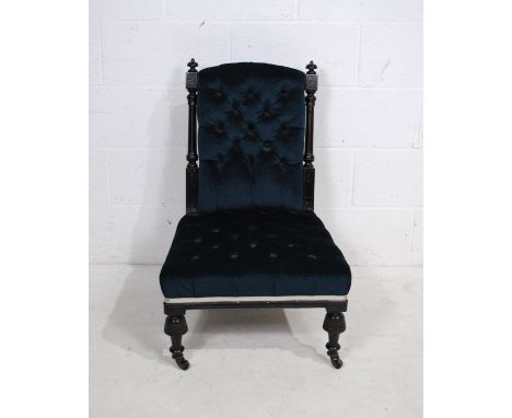 A Victorian ebonised nursing chair, with carved decoration and button-back detailing
