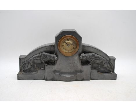 An Art Deco pewter mantel clock, the brass face surmounted by leopards - length 32cm, height 16cm