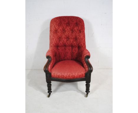 A Victorian mahogany framed upholstered armchair, with button-back detailing, raised on cabriole legs with carved detailing