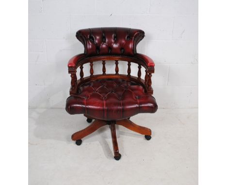 An oxblood leather Captains chair, with button-back detailing