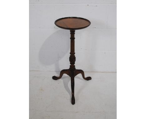 A turn of the century mahogany wine table, with carved detailing, raised on tripod base with claw feet