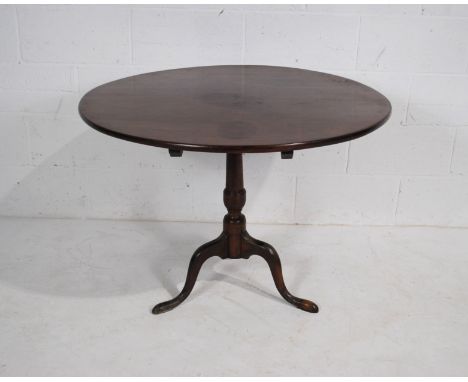 A Georgian mahogany circular tilt-top table, raised on tripod base with hoofed feet - diameter 98.5cm, height 73cm