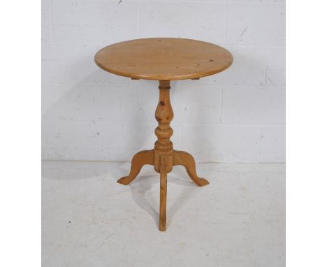 A circular pine tilt-top table, raised on turned tripod base - diameter 61cm, height 74cm