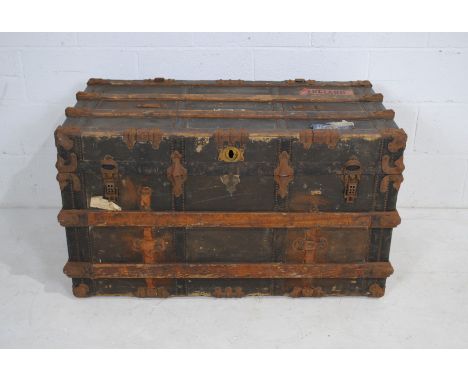 An antique wooden travel trunk, with various labels - brass lock plate loose but present. Length 106cm, depth 57cm, height 61