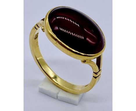 An 18ct gold ring set with a cabochon garnet, size L