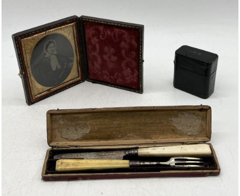 A small framed daguerreotype along with a hallmarked silver travelling cutlery set and a leather cased inkwell