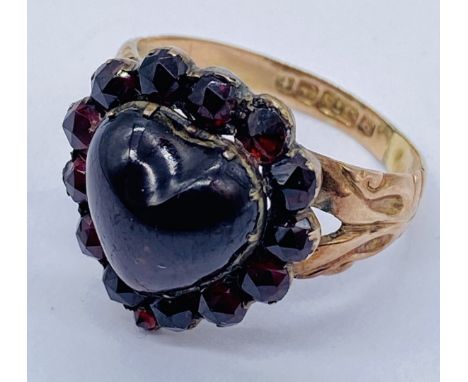 A 9ct gold mourning ring set with garnets, the central cabochon stone being heart shaped, size O