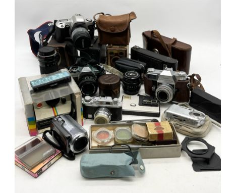A collection of various vintage cameras and accessories including Kodak Retina Reflex III, Polaroid 1000, Canon etc. 