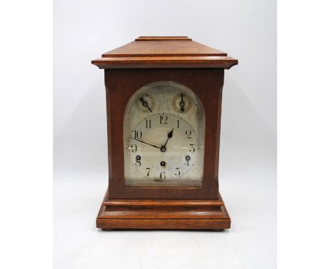 An oak chiming mantel clock, with silvered dial, with keys