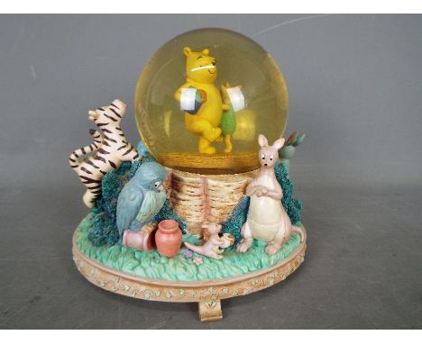 A Disney musical snow globe featuring Winnie The Pooh characters, approximately 18 cm (h).