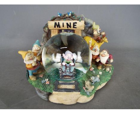 A Disney musical snow globe featuring the Seven Dwarfs from the film 'Snow White And The Seven Dwarfs', approximately 17 cm (