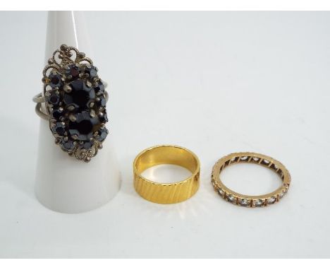 A yellow metal stone set eternity ring (unmarked) presumed 9ct gold, size N, approx weight 1.92 g and two further rings