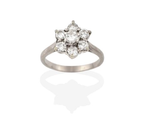 A Diamond Cluster Ring, the raised central round brilliant cut diamond within a border of round brilliant cut diamonds, in wh