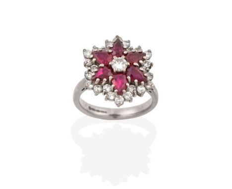 An 18 Carat White Gold Ruby and Diamond Cluster Ring, the central round brilliant cut diamond within a border of pear shaped 