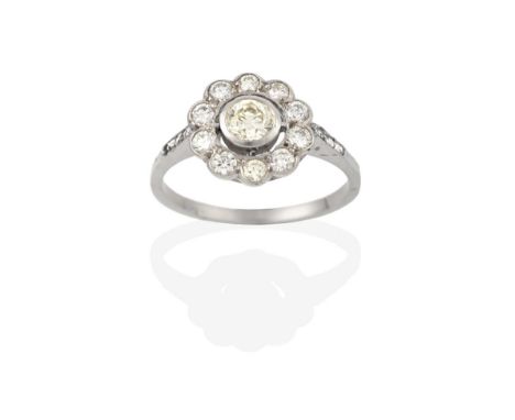 A Diamond Cluster Ring, the round brilliant cut diamond within a border of smaller round brilliant cut diamonds, in white cla