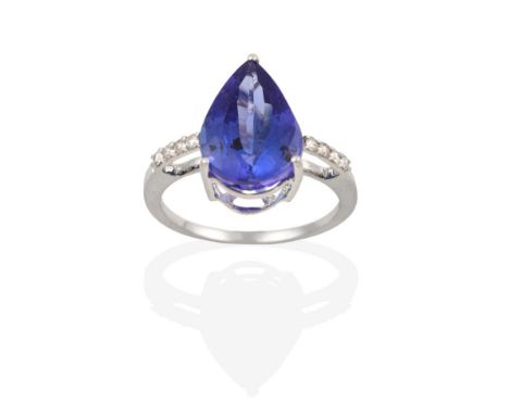 An 18 Carat White Gold Tanzanite and Diamond Ring, the pear shaped tanzanite in a claw setting, to an eight-cut diamond set s