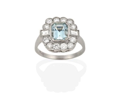 An Aquamarine and Diamond Cluster Ring, the emerald-cut aquamarine within a border of round brilliant cut and baguette cut di