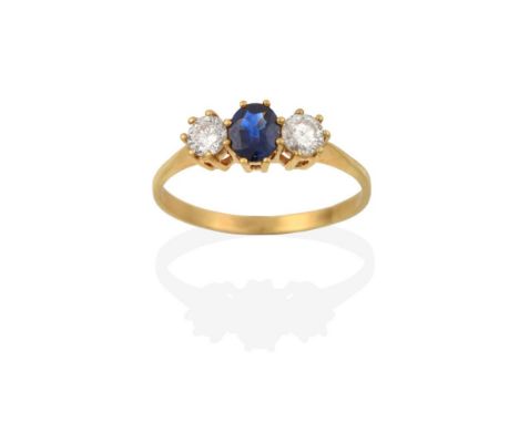 A Sapphire and Diamond Three Stone Ring, the oval cut sapphire flanked by round brilliant cut diamonds, in yellow claw settin