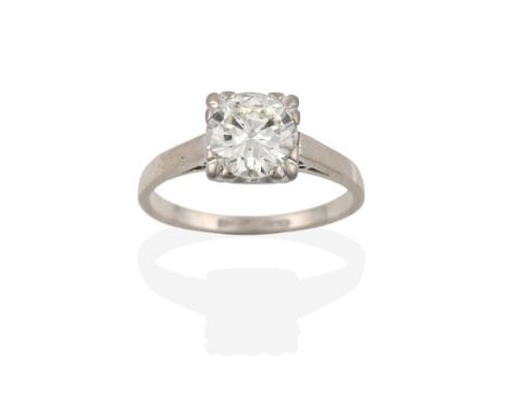 A Diamond Solitaire Ring, the round brilliant cut diamond in a white four claw setting, to a tapered shoulder plain polished 