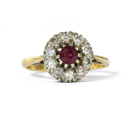 A gold ruby and diamond cluster ring, with a circular mixed cut ruby to surround of eight cut diamonds, all claw set in white