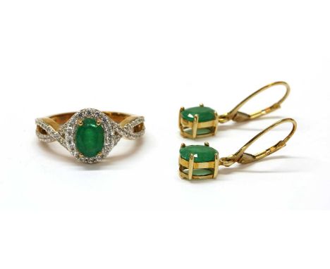 A 9ct gold emerald and zircon cluster ring, with an oval mixed cut emerald, approximately 7.5 x 5.5mm, claw set to surround o