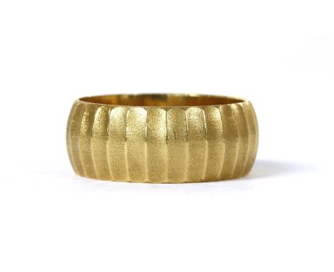 An 18ct gold patterned ‘D’ section wedding ring, with satin ribbed finish, London 1964, 7.04g.Finger size M