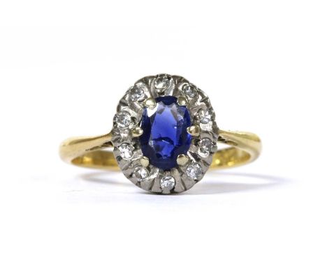 An 18ct gold sapphire and diamond cluster ring, with an oval mixed cut sapphire, claw set, to surround of eight cut diamonds,