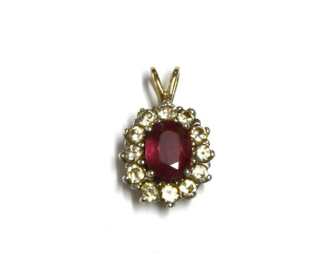 A gold ruby and diamond cluster pendant, with an oval mixed cut ruby, approximately 6.8 x 5.2mm, claw set, to surround of bri