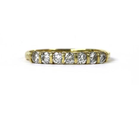 An 18ct gold diamond half eternity ring, with a row of seven brilliant cut diamonds, bar set, to flat section shank, London 1