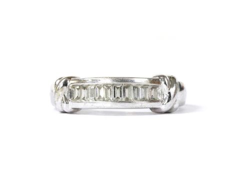 A 9ct white gold diamond half eternity ring, with a row of baguette cut diamonds, channel set, to cross motif shoulders and a