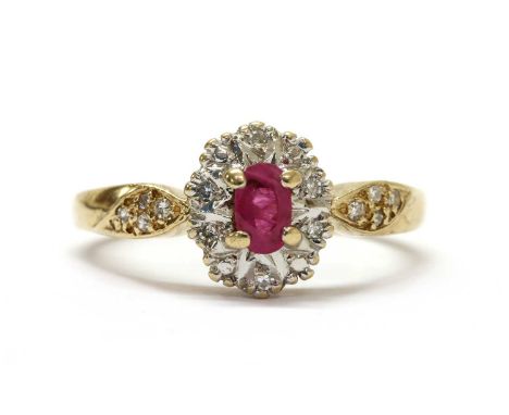 A 9ct gold ruby and diamond cluster ring, with an oval mixed cut ruby, claw set, to surround of eight cut diamonds, grain set