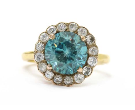 A gold blue zircon and white sapphire cluster ring, with a round mixed cut blue zircon, approximately 8.4mm diameter, claw se