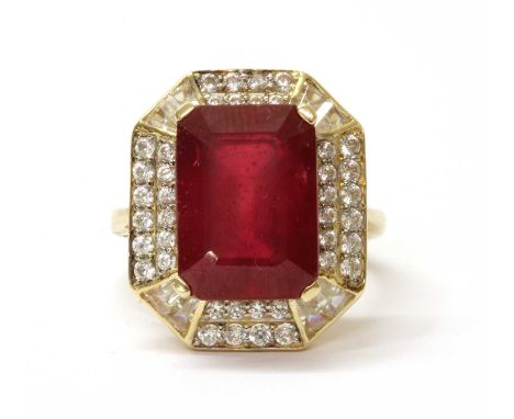 A 9ct gold fracture filled ruby and zircon ring, with an emerald cut fracture filled ruby, approximately 14 x 10mm, claw set 