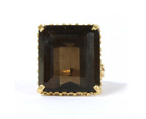 A gold single stone smoky quartz ring, with an octagonal step cut smoky quartz, approximately 20 x 18mm, claw set, to a twist