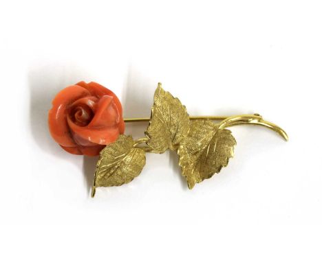 An Italian gold carved coral brooch, in the form of a rose, with a carved coral flower head, to gold stem and leaves, with pi