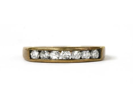 A 9ct gold half eternity ring, with a row of brilliant cut diamonds, channel set, to tapered shoulders and a plain shank, imp