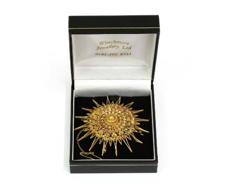 A gold star brooch/pendant, with radiating rows of studs to border of wire rays, with pin, roller catch and wire pendant bale