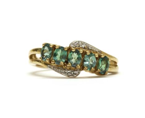 A 9ct gold gemstone and diamond set ring, with a row of oval mixed cut green gemstones, possibly alexandrite, claw set, to cr