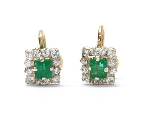 A pair of silver and gold emerald and white sapphire cluster earrings, with a square step cut emerald, claw set, to surround 