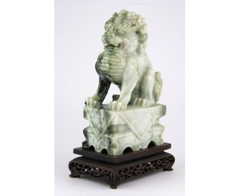 A fine Chinese carved jade lion dog figure on a carved wooden base, overall H. 18cm.