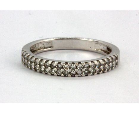An 18ct white gold half eternity ring set with two rows of brilliant cut diamonds, (K),