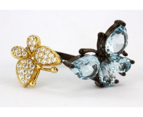 A 925 silver butterfly shaped adjustable ring set with pear and oval cut Swiss blue topaz and white stones.