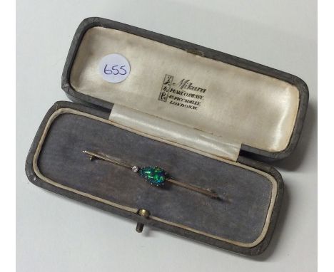 An attractive black opal and diamond brooch in 18 carat gold claw knife edge mount. Approx. 3.6 grams. Est. £200 - £250.