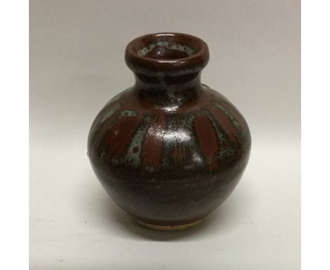 MUCHELNEY: A John Leach miniature glazed stoneware pottery bud vase of wax resistant design. Impressed mark to base. Approx. 