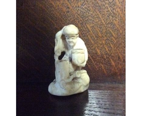 A small carved ivory netsuke of an Oriental man. Est. £20 - £30.