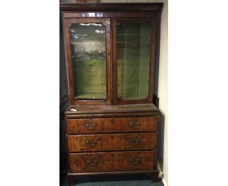A good walnut veneered bookcase on bracket feet with brass handles. Est. £80 - £120.
