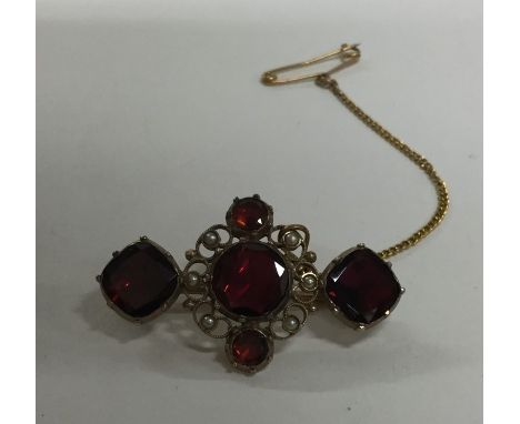 A garnet and pearl Antique brooch set with safety chain. Approx. 3.3 grams. Est. £30 - £50.