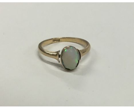 An opal single stone ring in rubover gold mount. Approx. 3 grams. Est. £50 - £80.