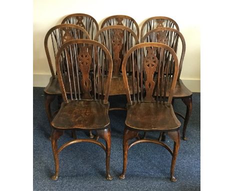 A set of eight oak Windsor chairs with stick backs on curved stretcher bases. Est. £100 - £150.